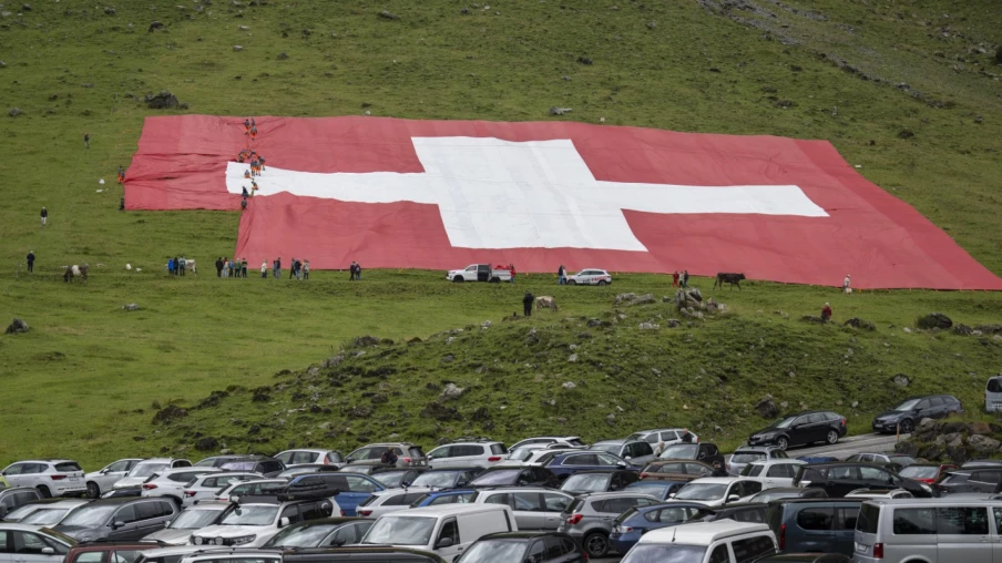 Le vent déchire un drapeau suisse géant au Säntis lors de la Fête nationale